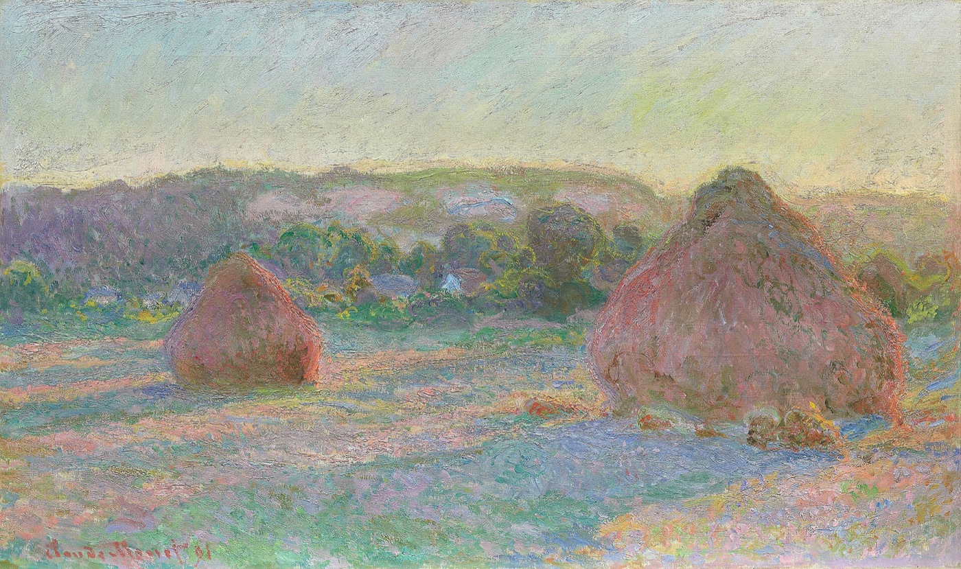 Stacks of wheat glow against a pink and blue late-summer sky.